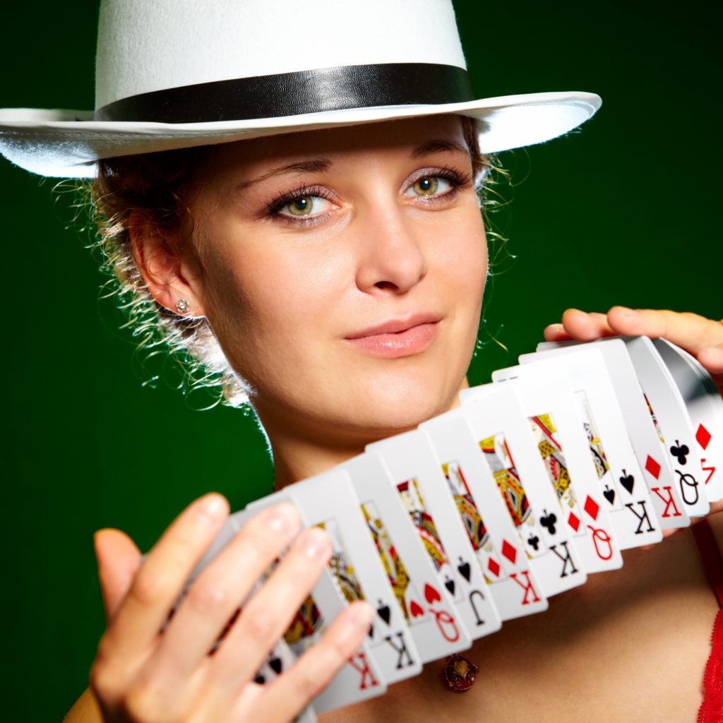 Молодая девушка в шляпе с картами в руках
