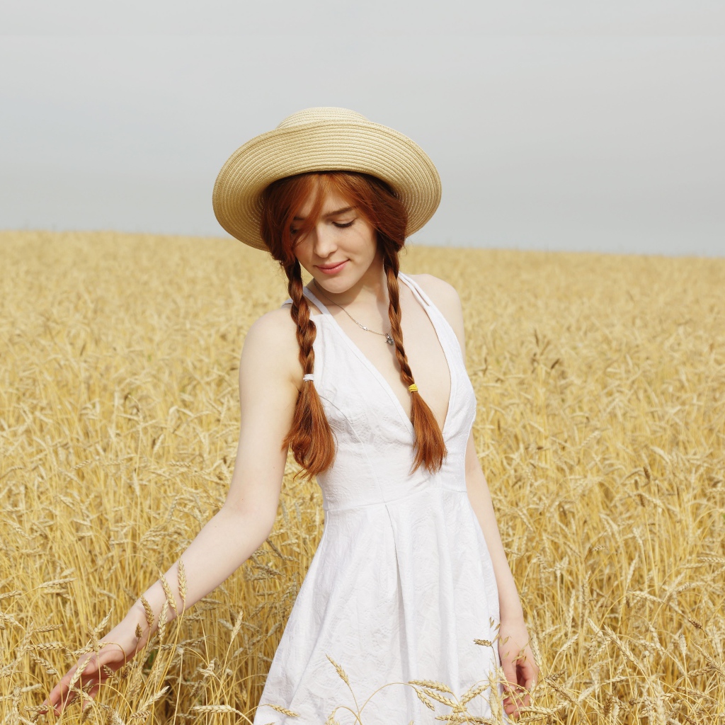Молодая девушка в белом платье на поле с пшеницей