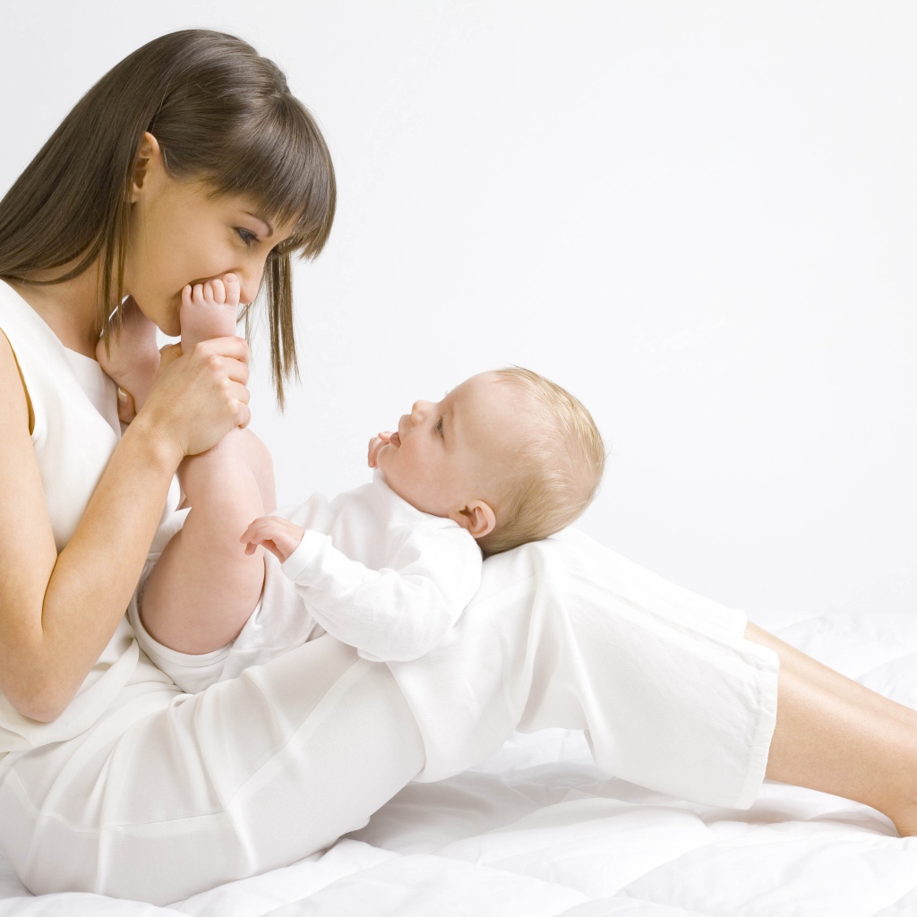 Молодая девушка в белом с младенцем