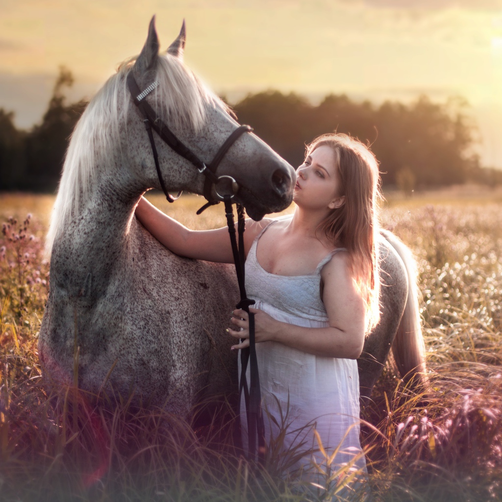 Молодая девушка с лошадью на поле