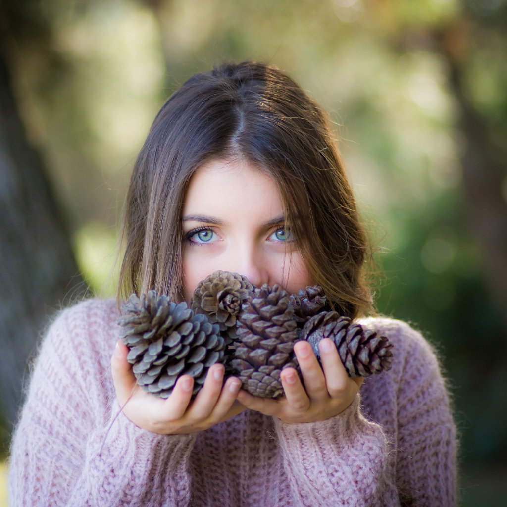 Молодая девушка с шишками в руках