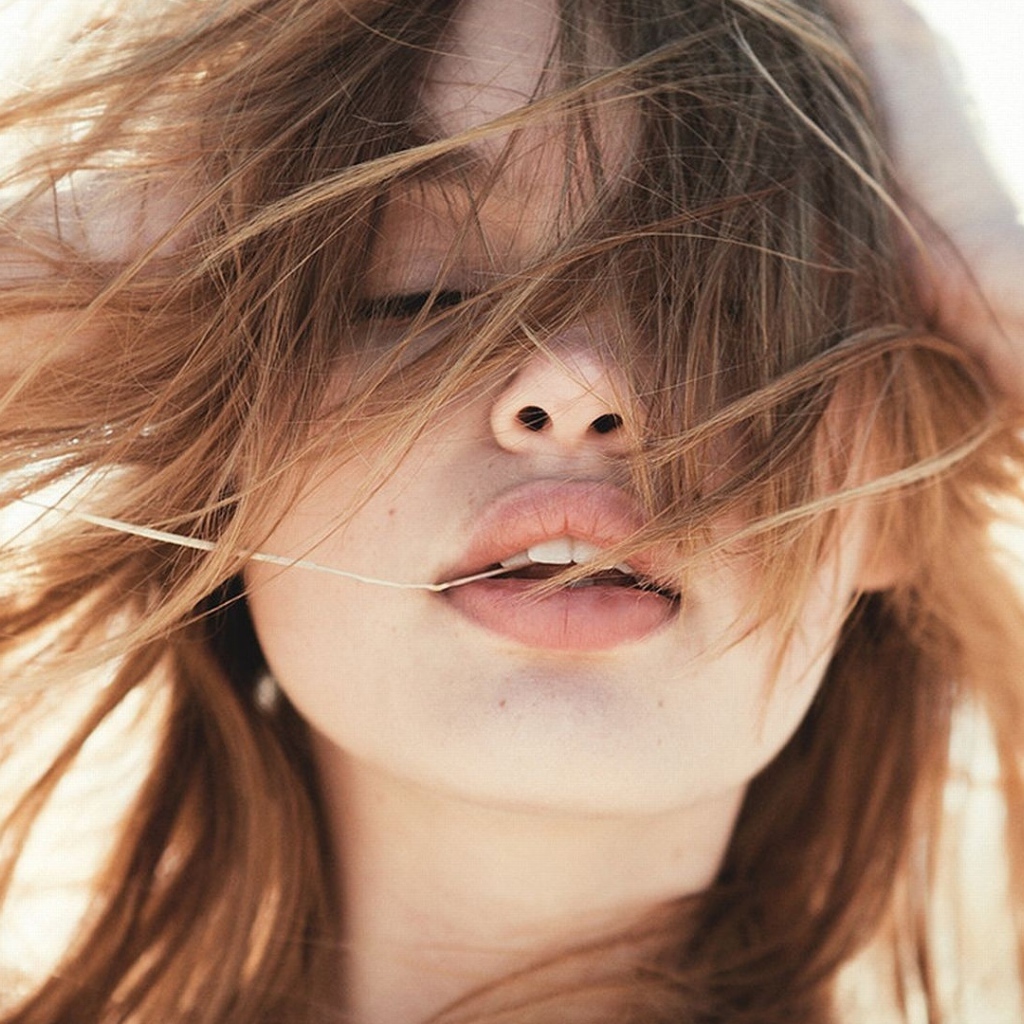 Молодая девушка с распущенными волосами на ветру