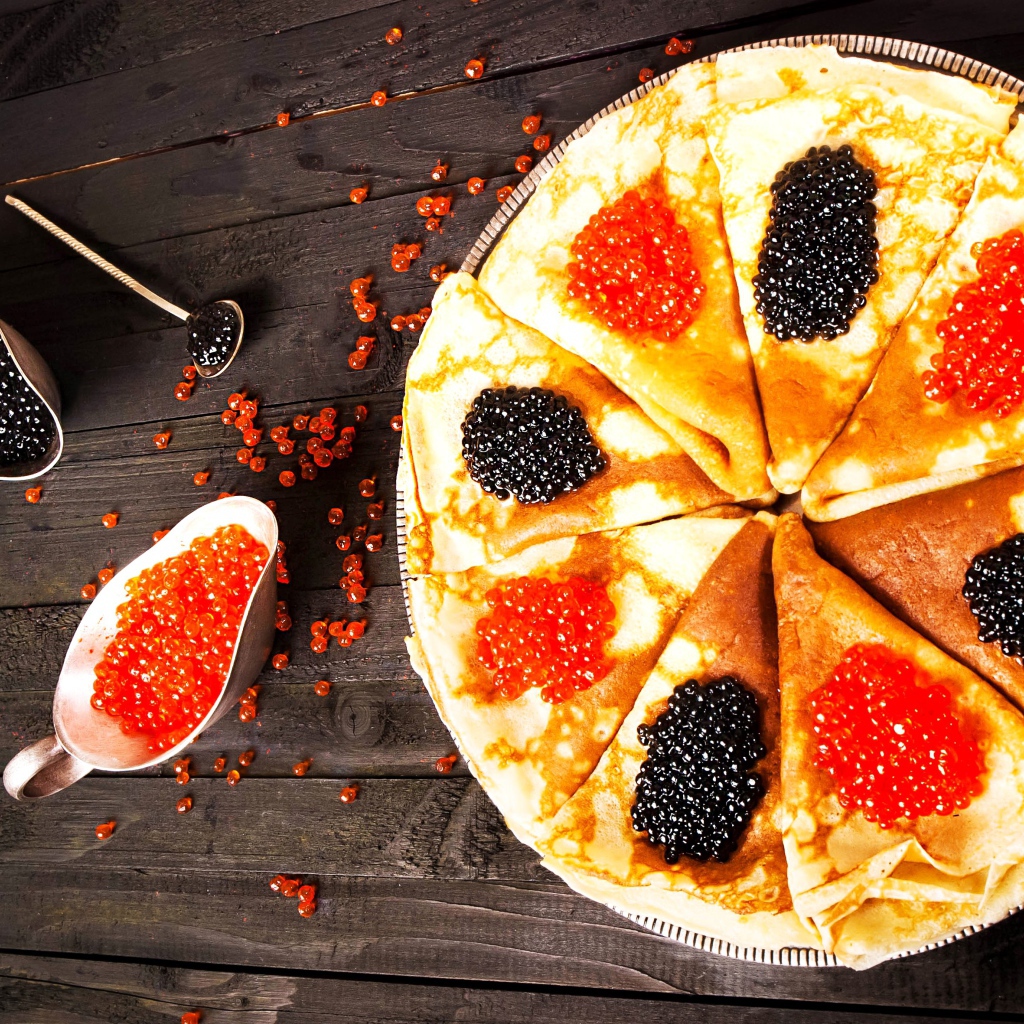 Блины с черной и красной икрой на деревянном столе на Масленицу