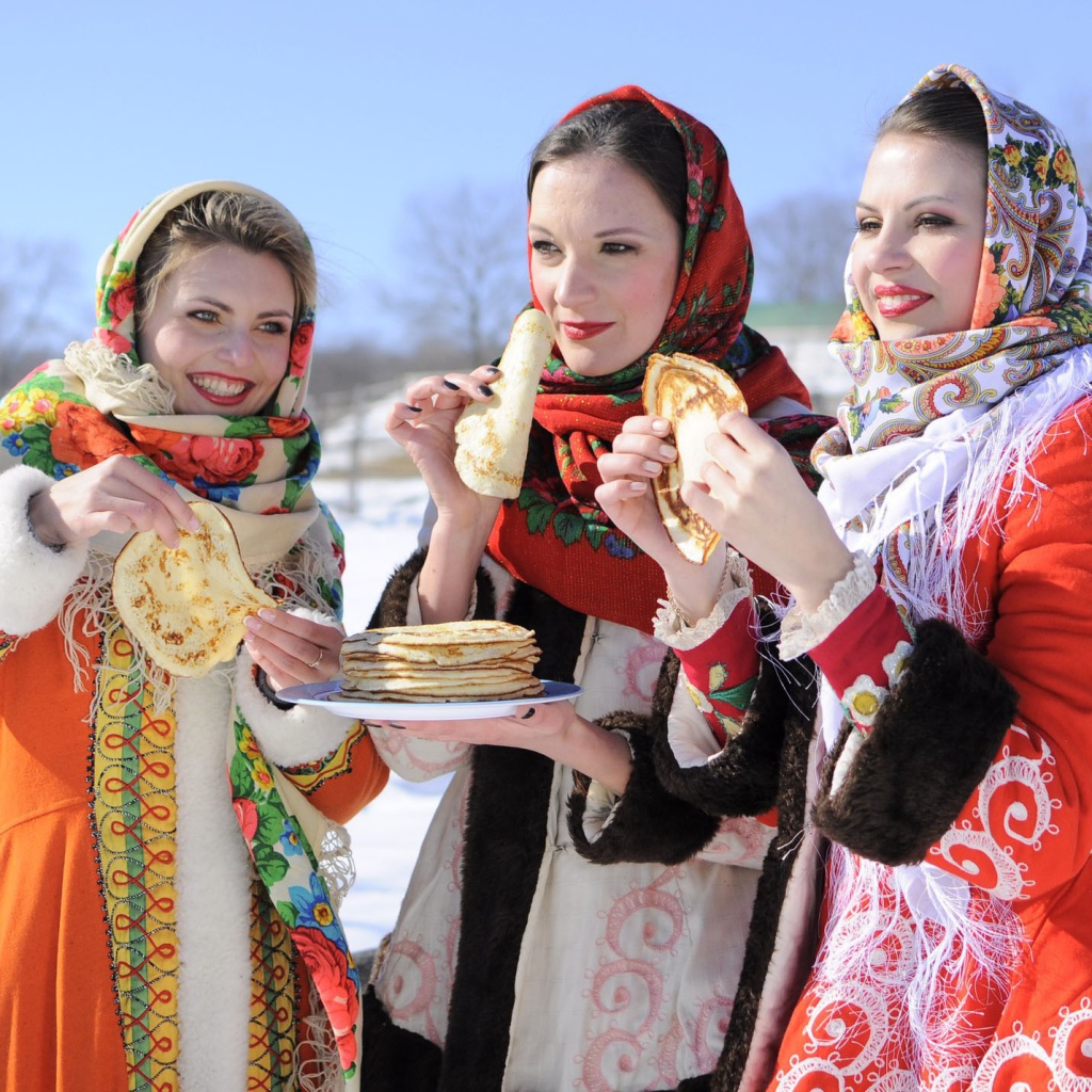 Три молодые красивые девушки с блинами на Масленицу
