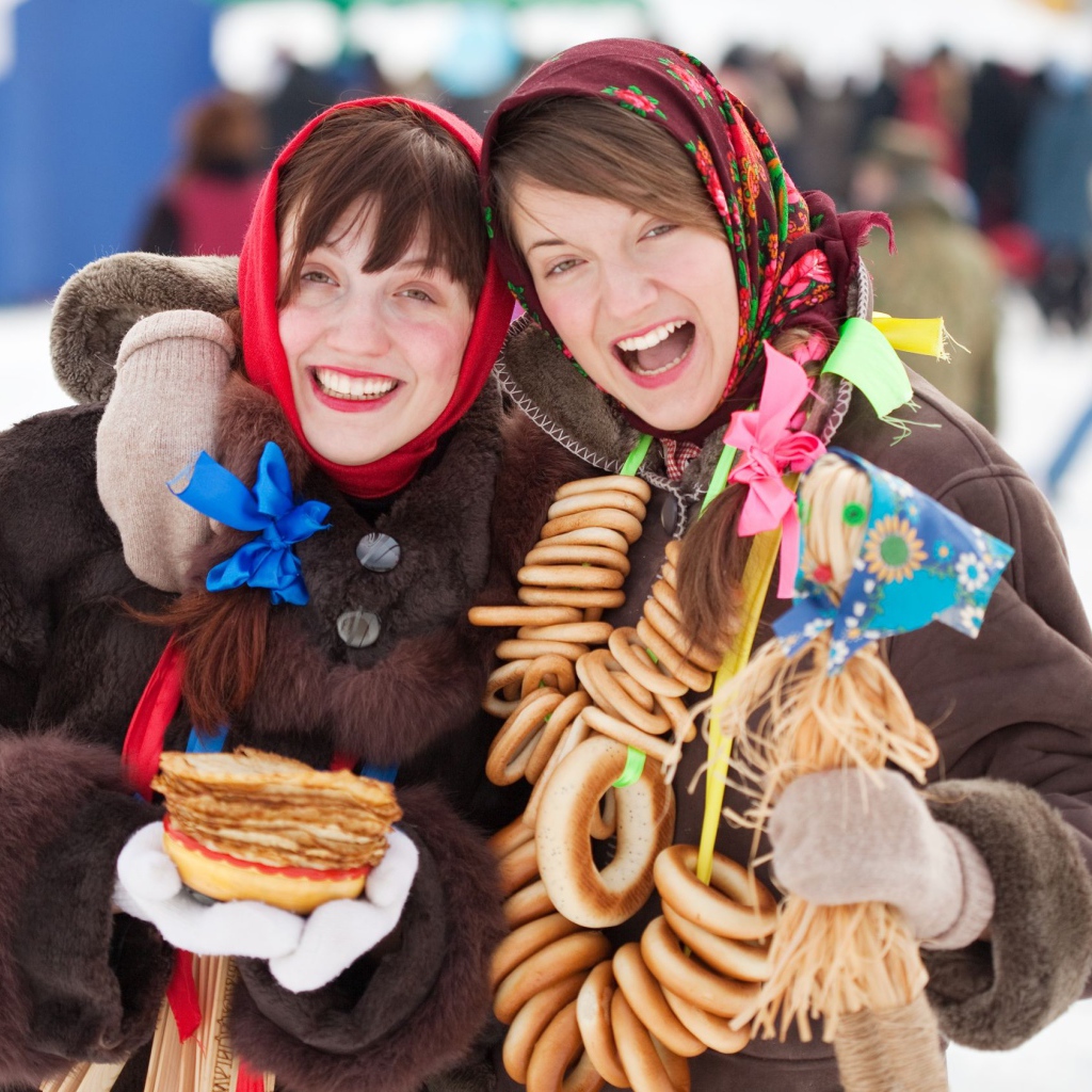 Две девушки с блинами и баранками на Масленицу