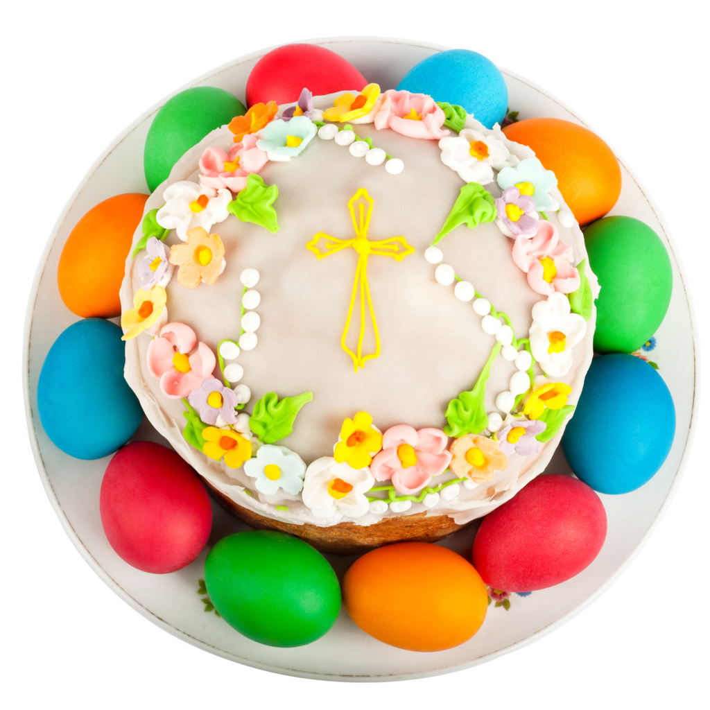 Красивый пасхальный кулич с цветами и разноцветными крашеными яйцами на белом фоне