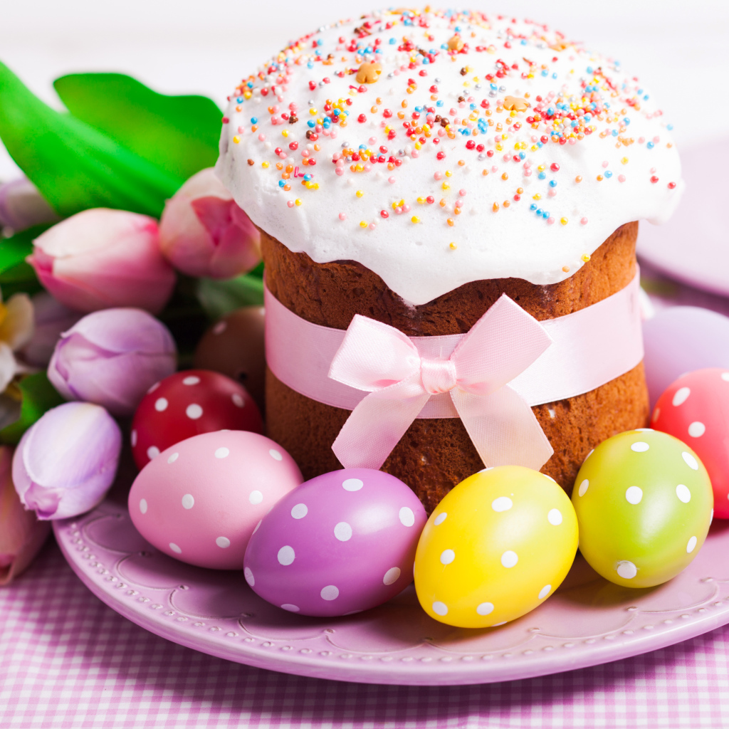 Пасхальный кулич с крашеными яйцами и букетом цветов