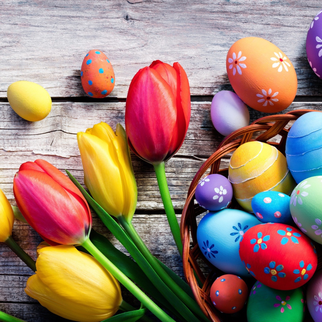 Крашеные яйца на столе с тюльпанами на Пасху