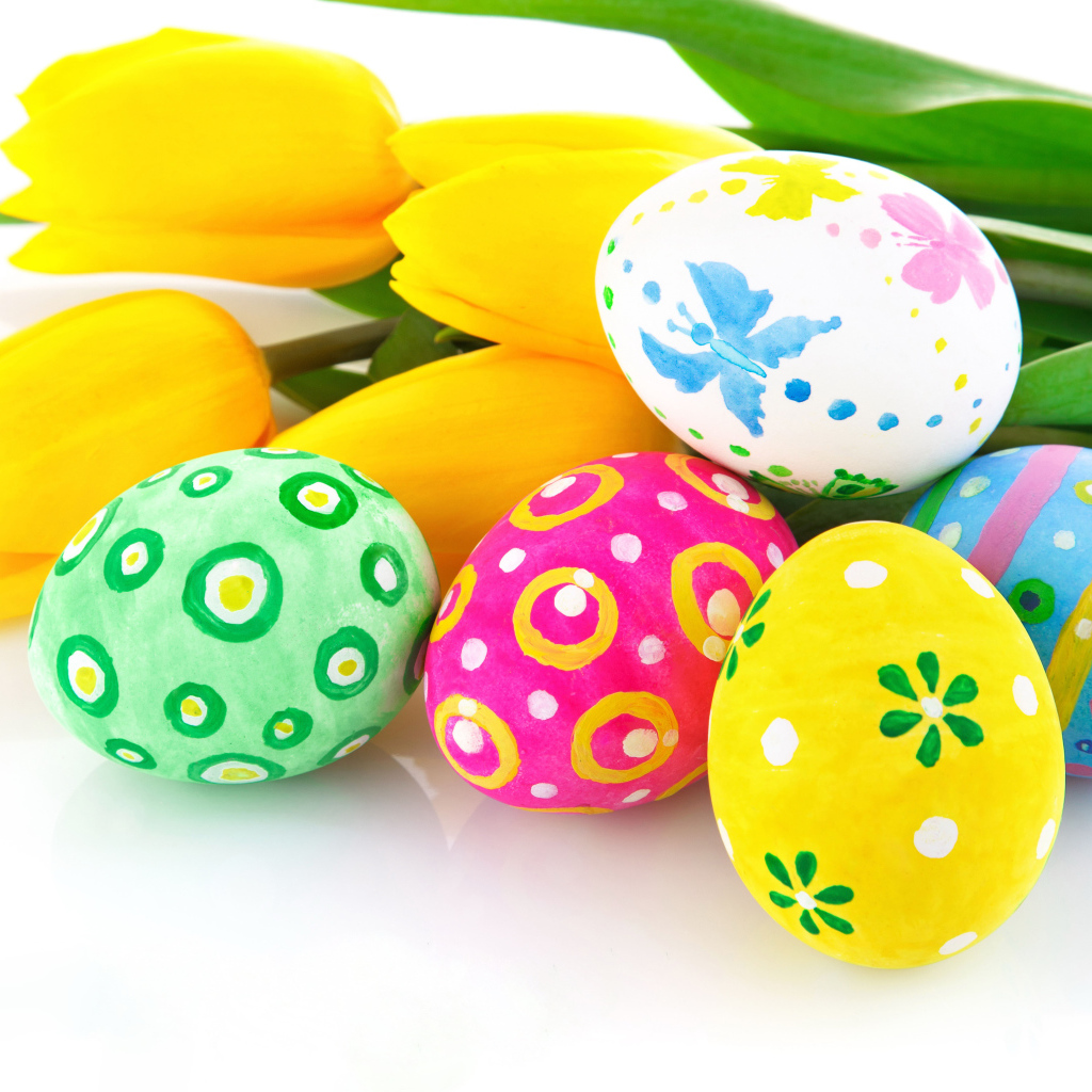 Разукрашенные яйца с букетом желтых тюльпанов на белом фоне на Пасху