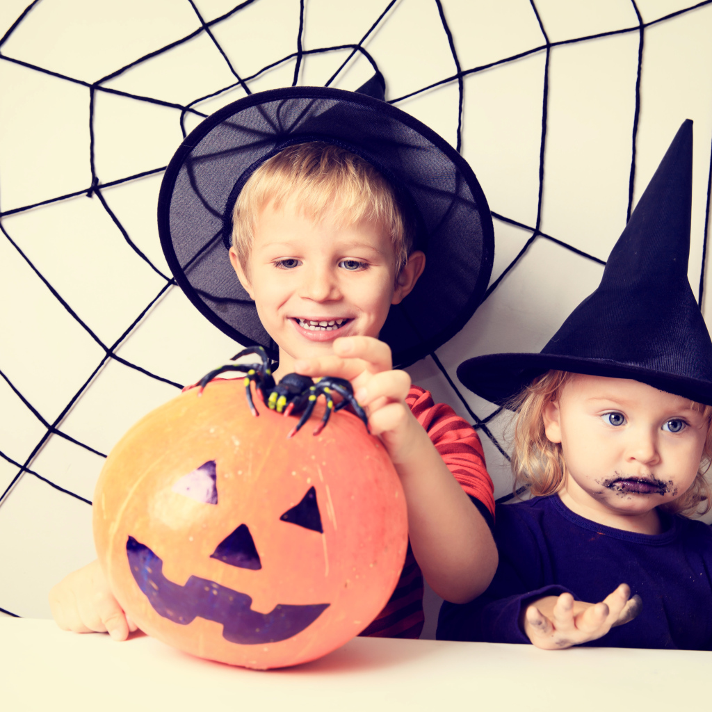 Маленькие мальчик и девочка в костюмах на Хэллоуин