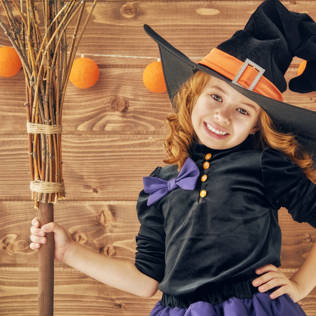 Маленькая девочка в костюме ведьмы на праздник Хэллоуин