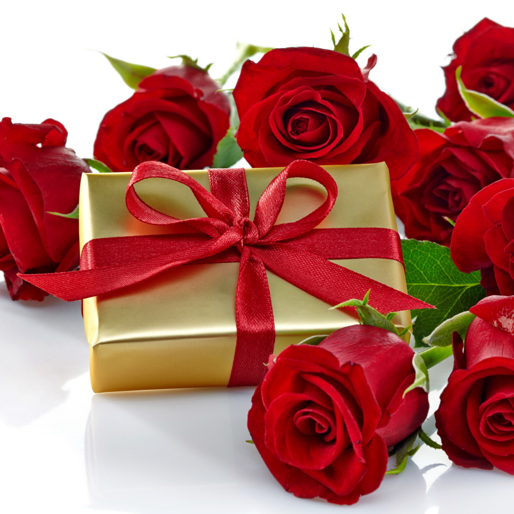 Подарок и букет красных роз на белом фоне к празднику 8 марта