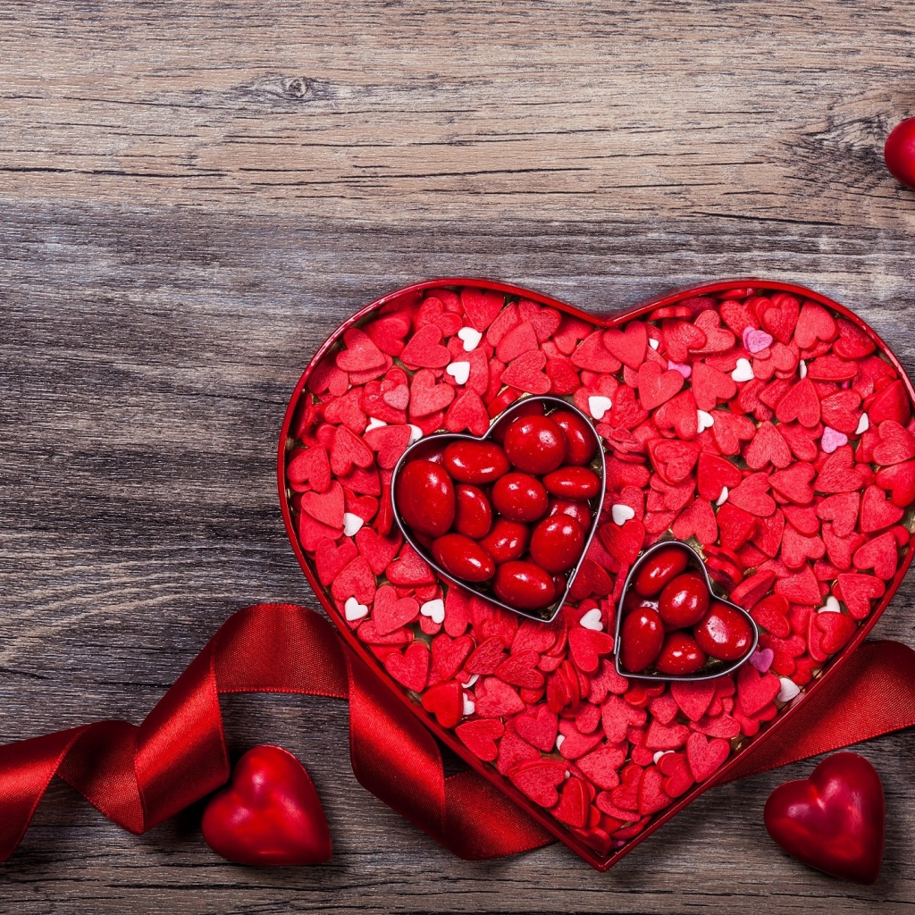 Коробка конфет в форме сердца с красной лентой в подарок