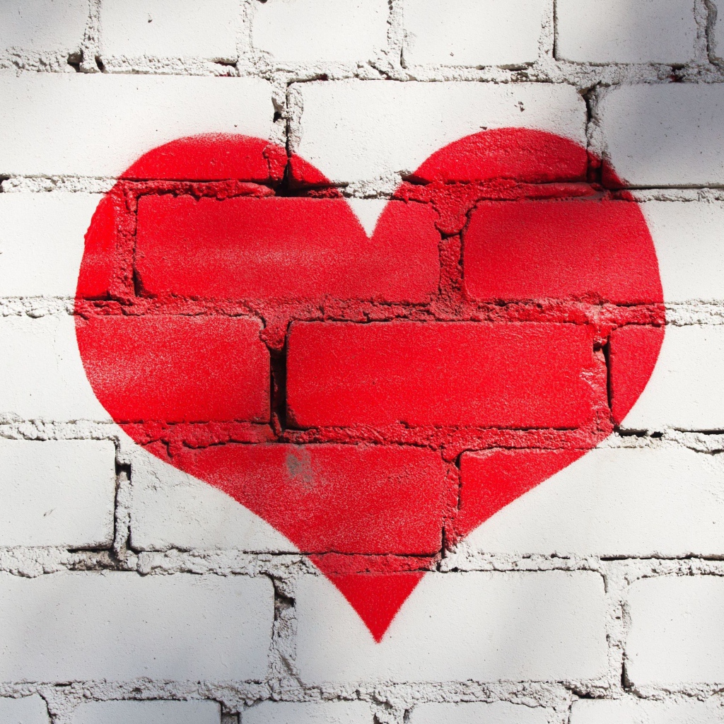 Большое красное сердце нарисовано на кирпичной стене