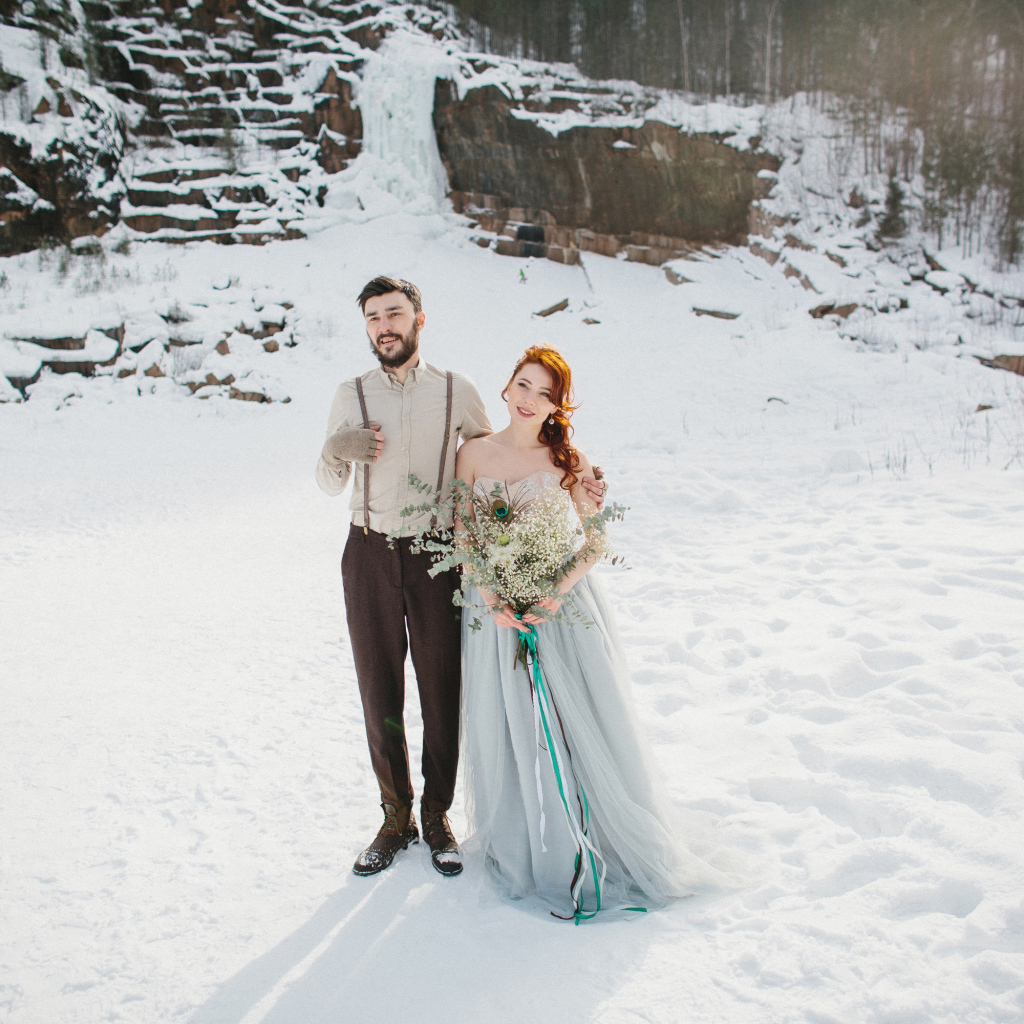 Влюбленная пара молодоженов стоит на снегу