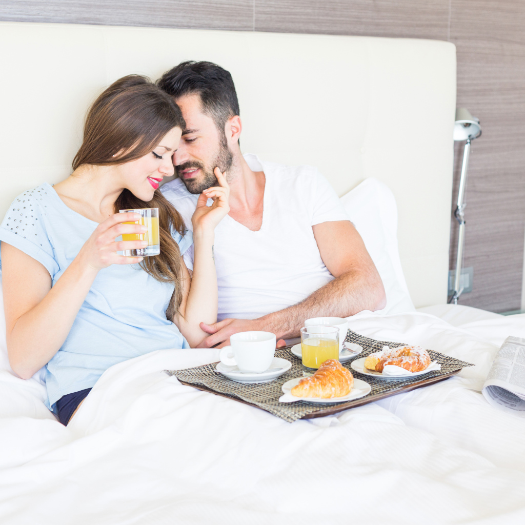 Влюбленная пара с завтраком в постели