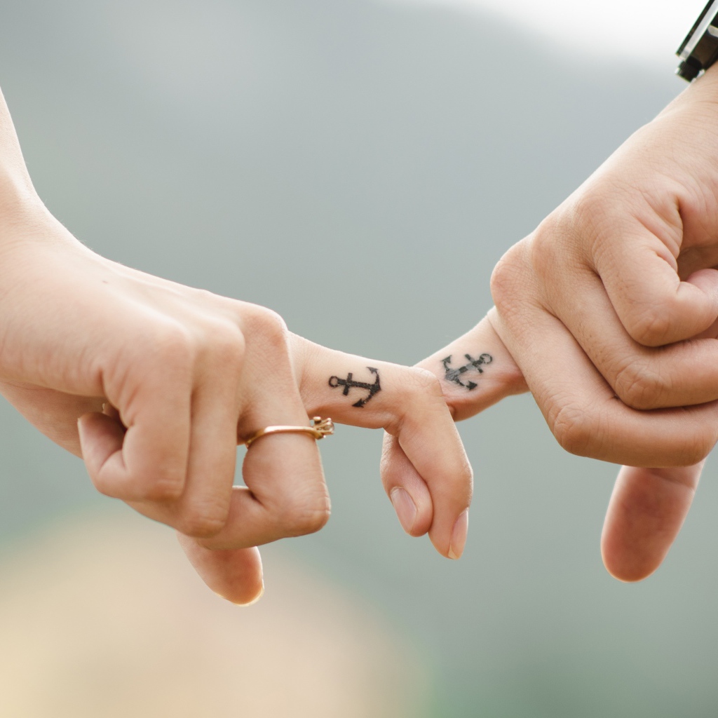 Руки влюбленной пары с татуировками на руках 