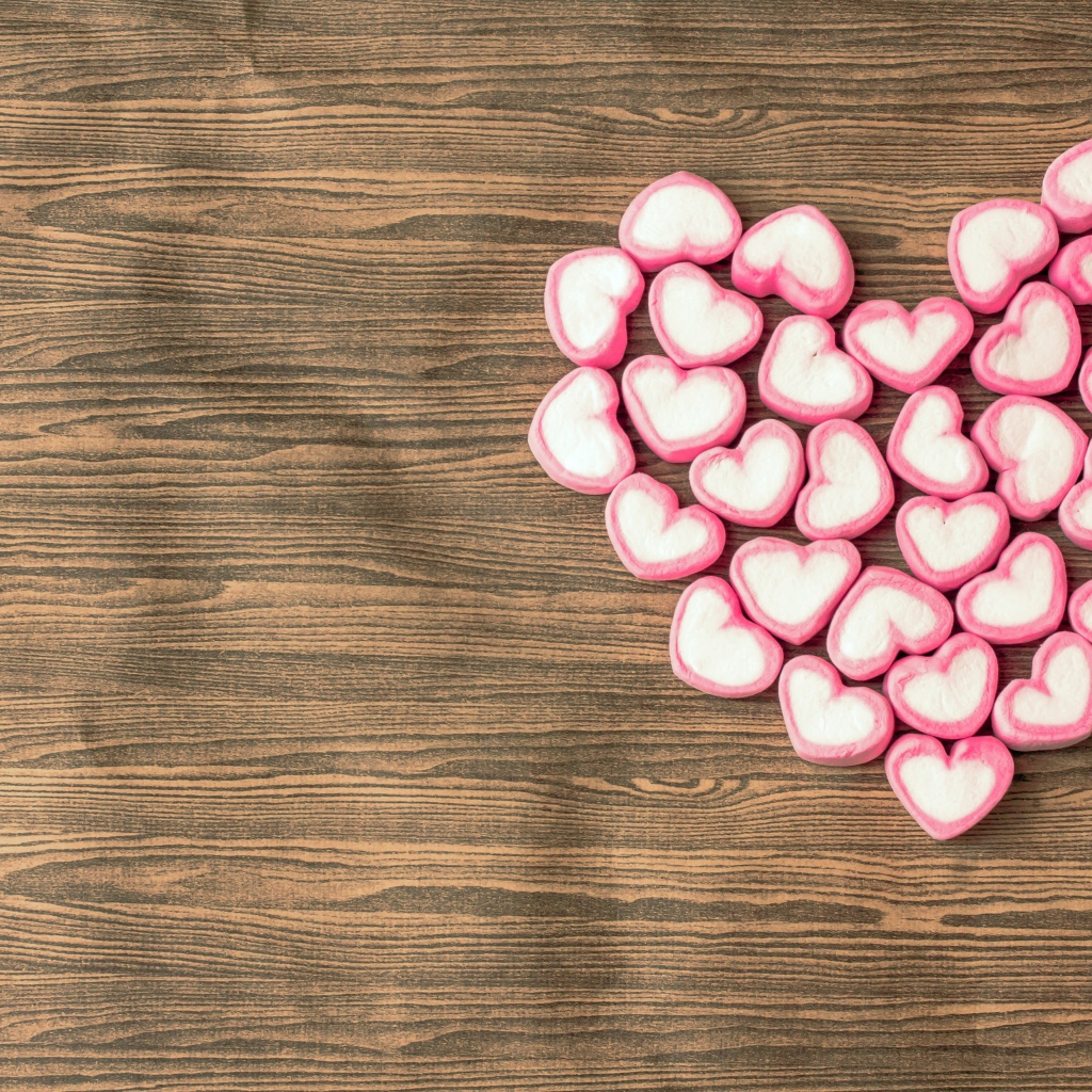 Сердце из конфет в форме сердца на деревянном столе