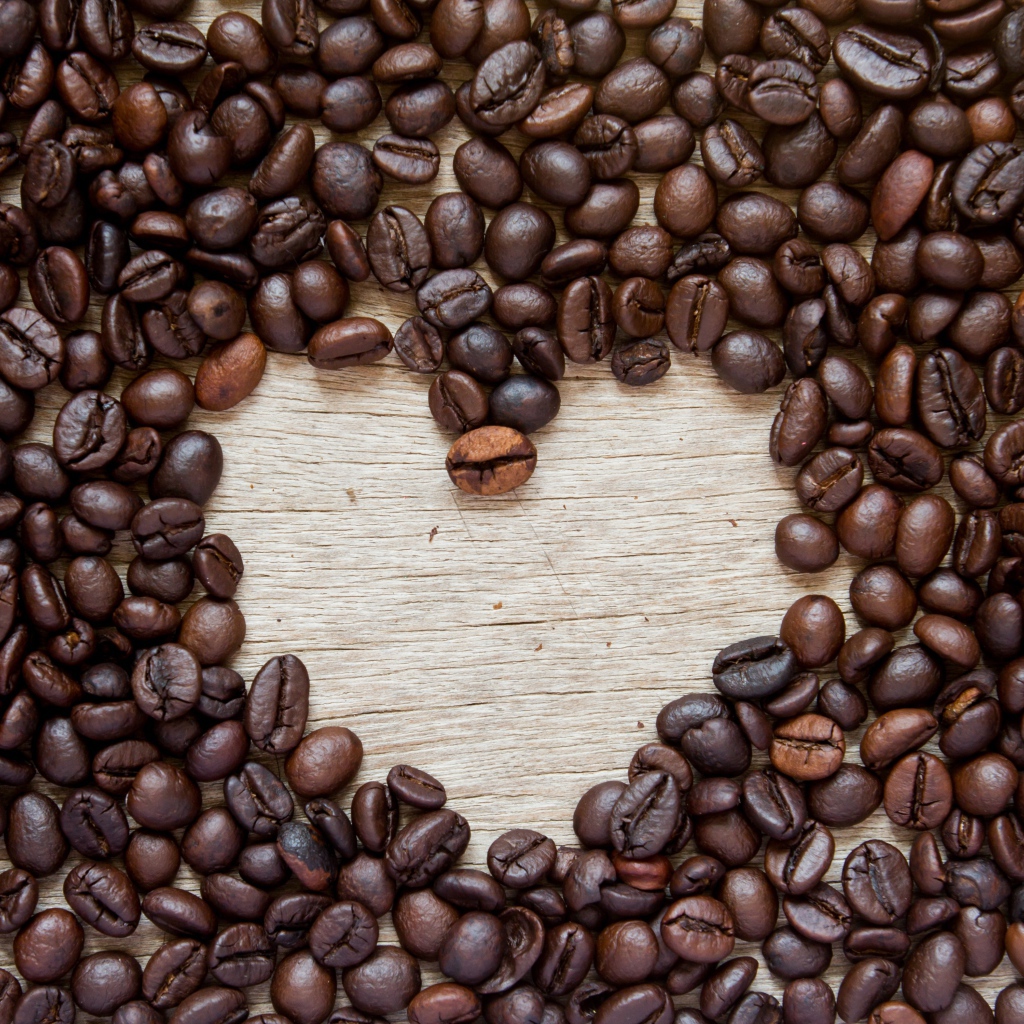 Сердце из кофейных зерен на деревянном столе 