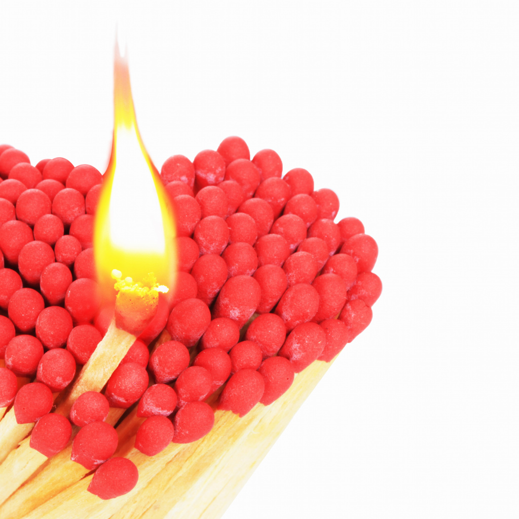 Сердце из спичек с красной серой на белом фоне