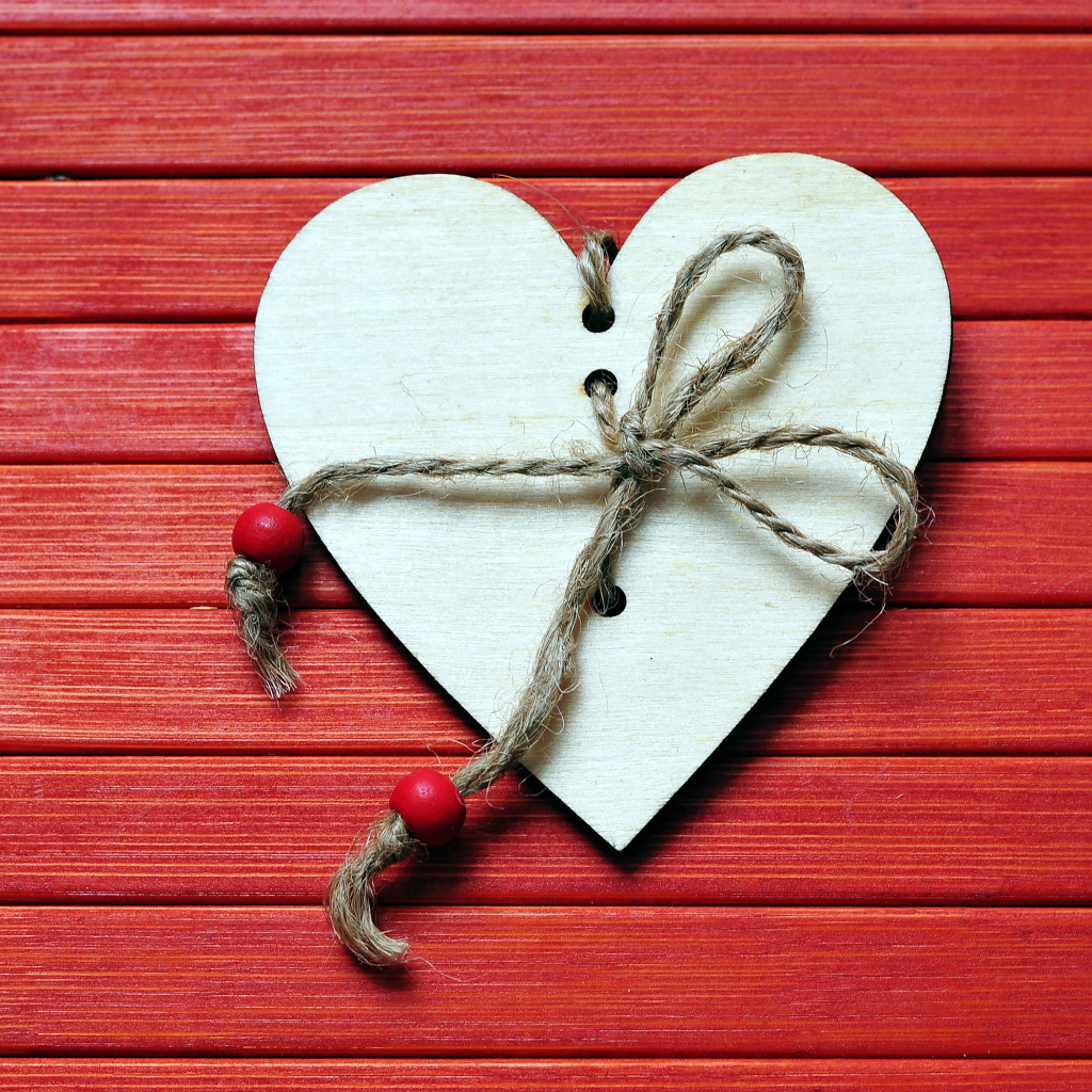 Сердце с веревкой на красном деревянном фоне