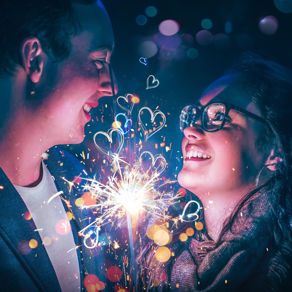 Влюбленные парень и девушка с бенгальским огнем в руке