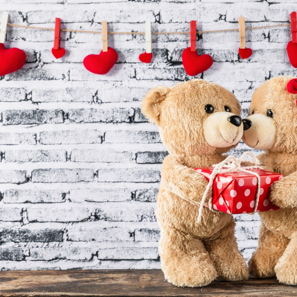 Влюбленные плюшевые мишки на фоне стены с сердечками 