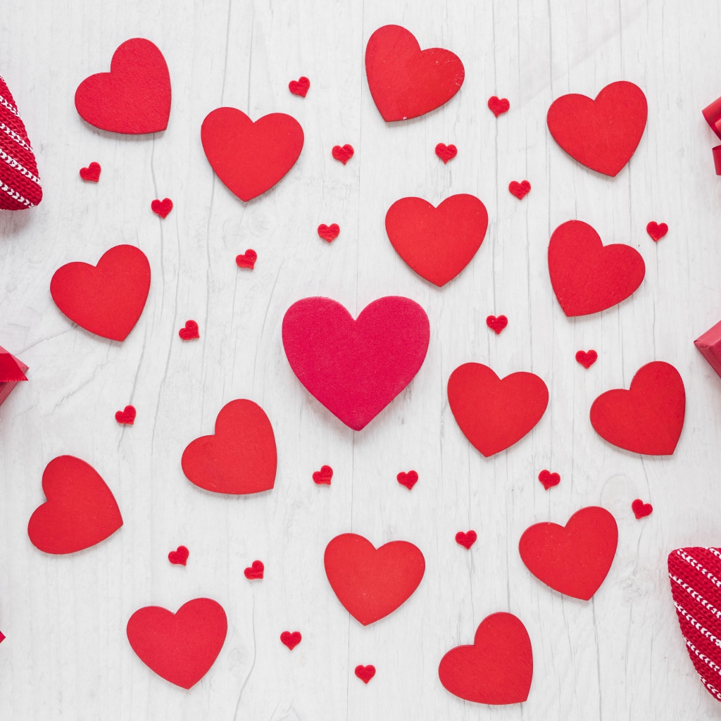 Много красных сердечек на столе с подарками 