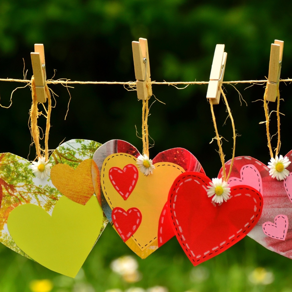 Бумажные сердечки висят на веревке на прищепках