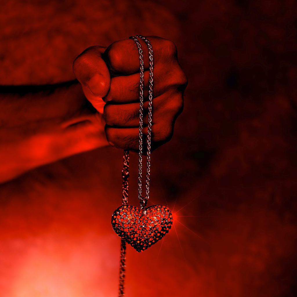 Кулон с сердцем на цепочке в мужской руке 