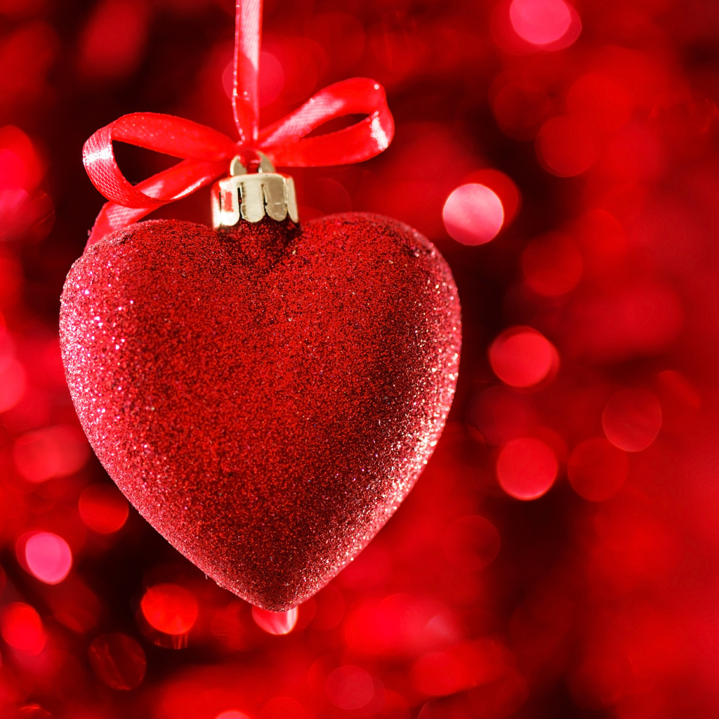 Красное большое блестящее сердце с лентой на красном фоне