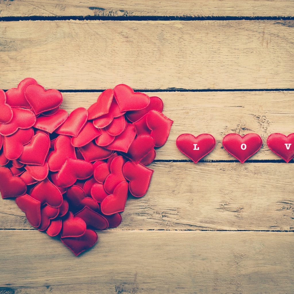 Маленькие красные сердечки на деревянной поверхности 