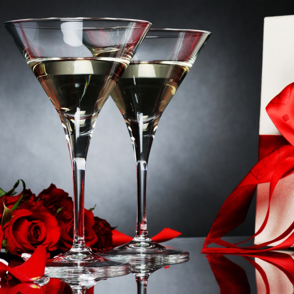 Два бокала с мартини, подарком и красными розами для любимой