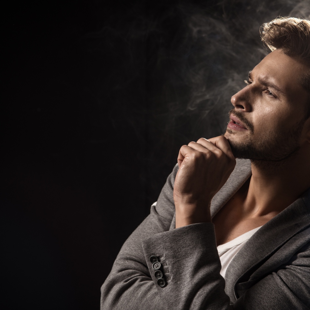 Красивый задумчивый мужчина в сером пиджаке