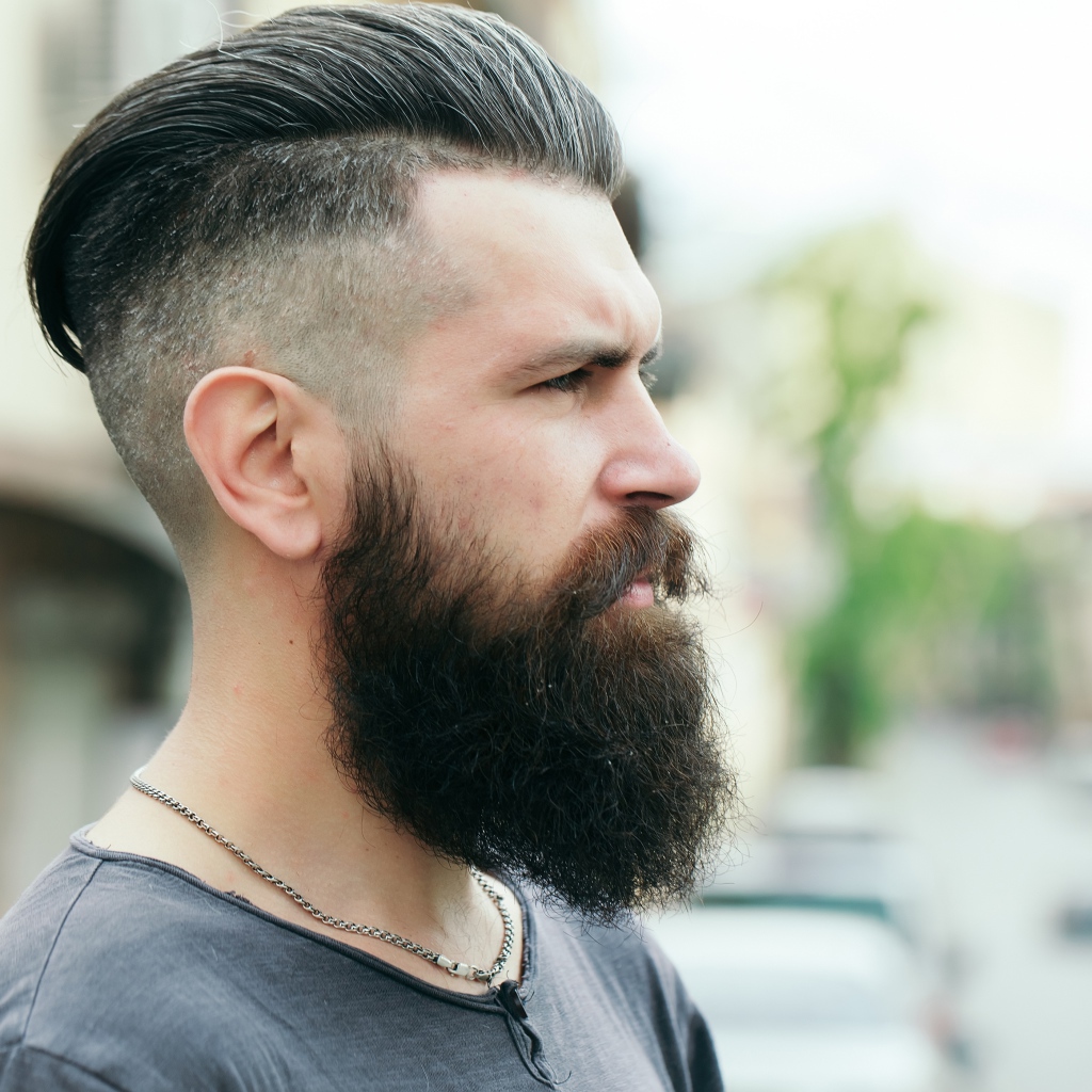 Стильный мужчина с бородой и прической на голове 