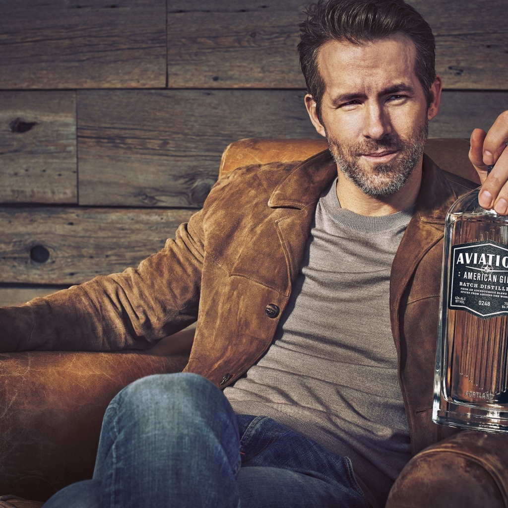 Актер Райан Рейнольдс в кресле с бутылкой в руке