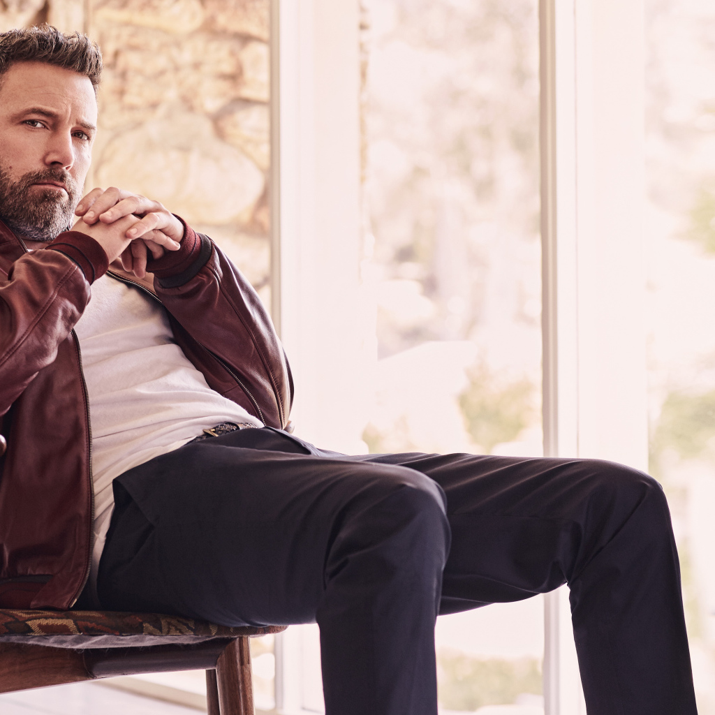 Популярный актер Бен Аффлек сидит на стуле