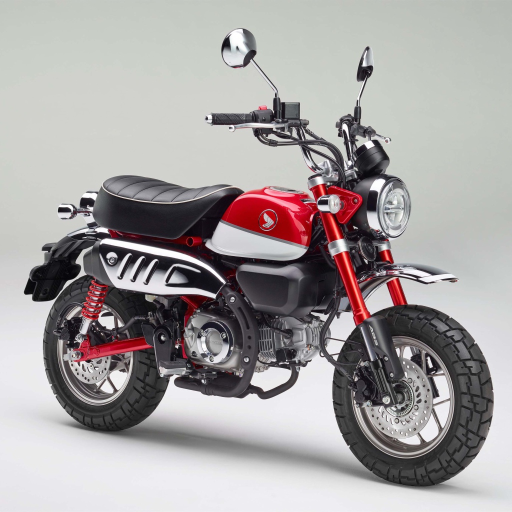 Красный мотоцикл Honda Monkey, 2018 года на сером фоне