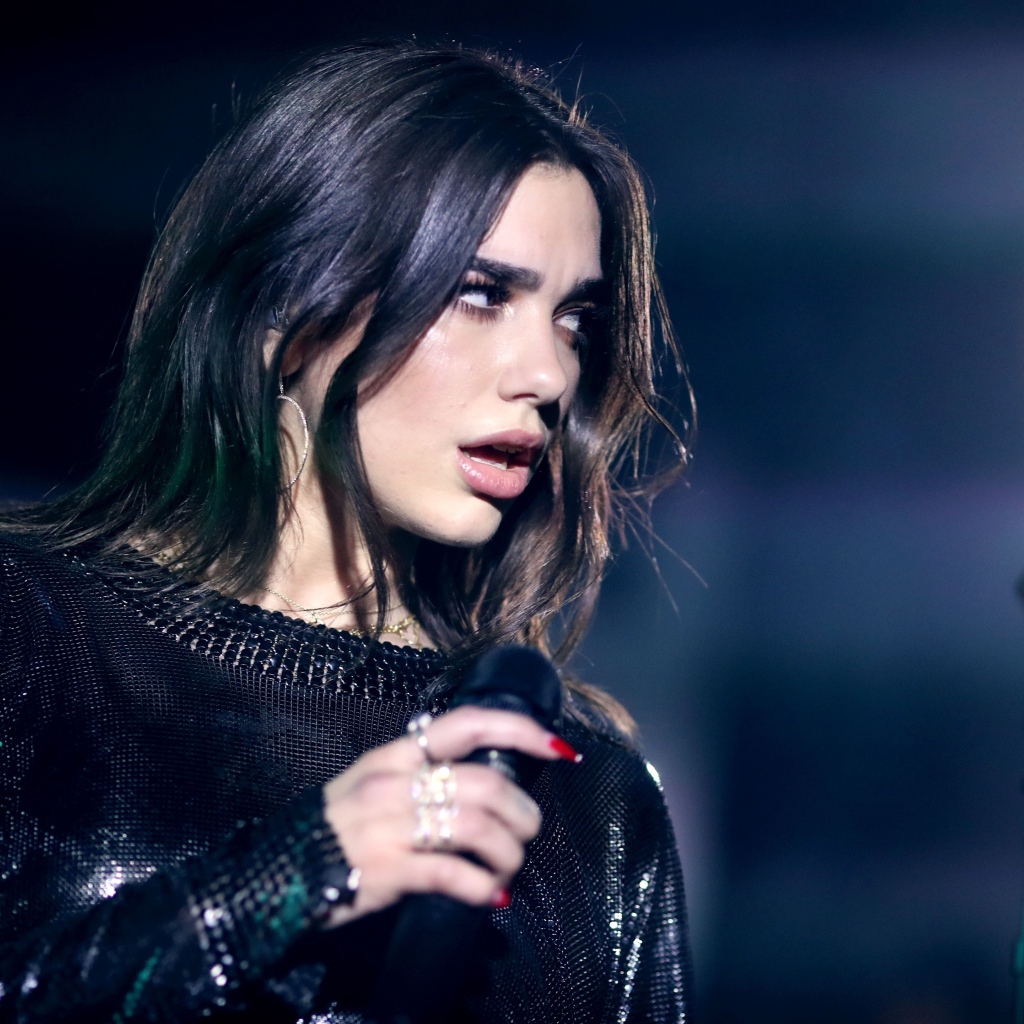 Британская певица Дуа Липа с микрофоном в руках