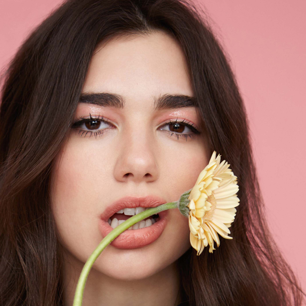 Певица Дуа Липа с цветком герберы во рту