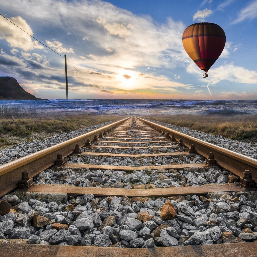 Воздушный шар в красивом голубом небе над железной дорогой