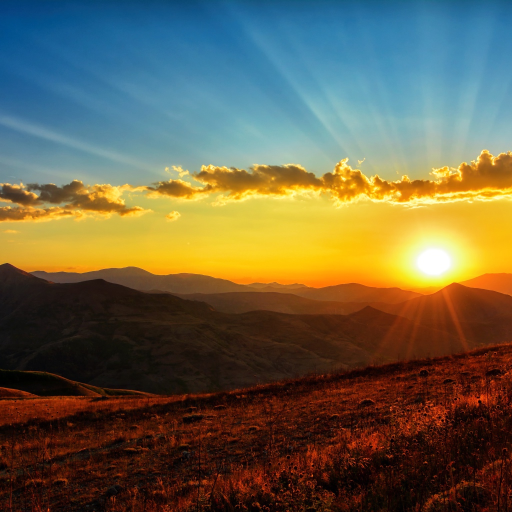 Beautiful dawn in the sky above the green hills