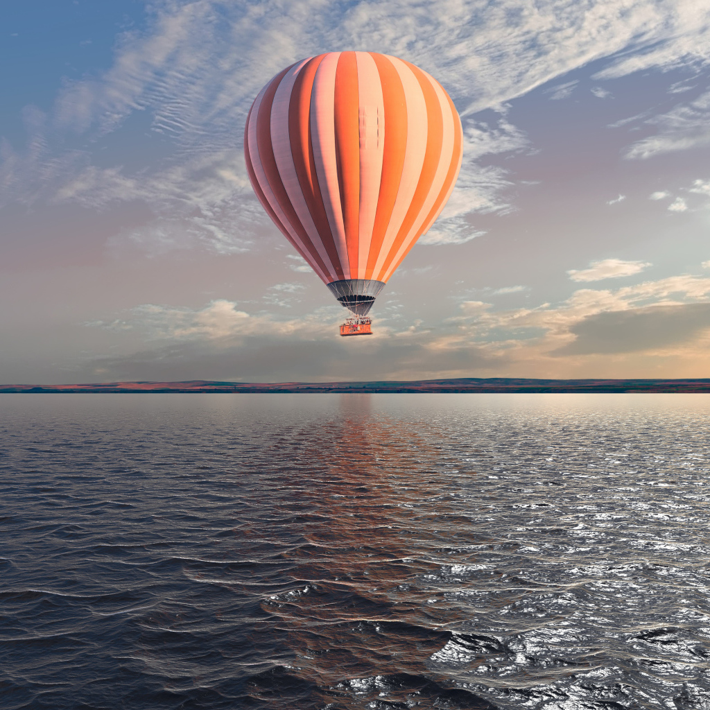 Большой воздушный шар над морем в голубом небе 