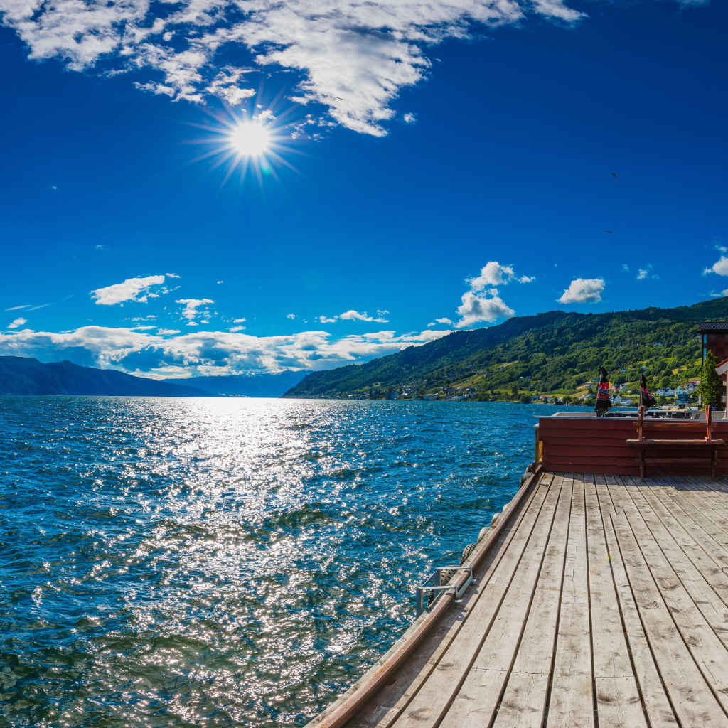 Яркое солнце в голубом небе над водой, Исландия