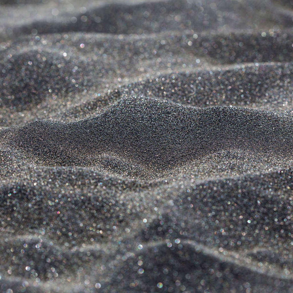 Блестящий черный песок крупным планом