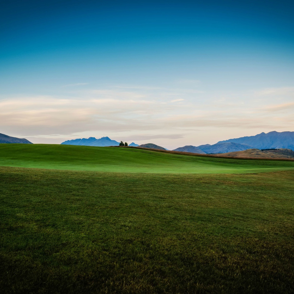 Зеленый луг на фоне красивого неба