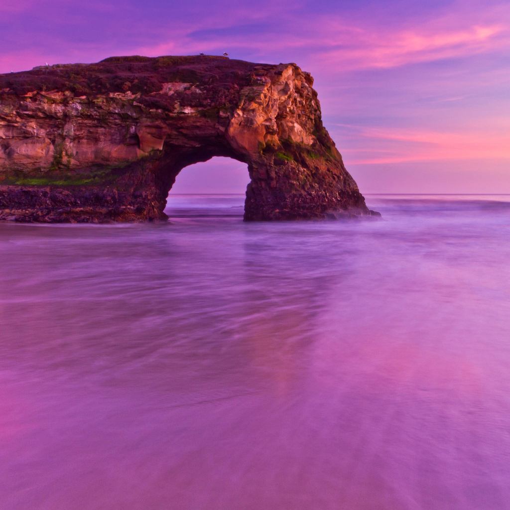 Гора с аркой в океане на фоне красивого неба