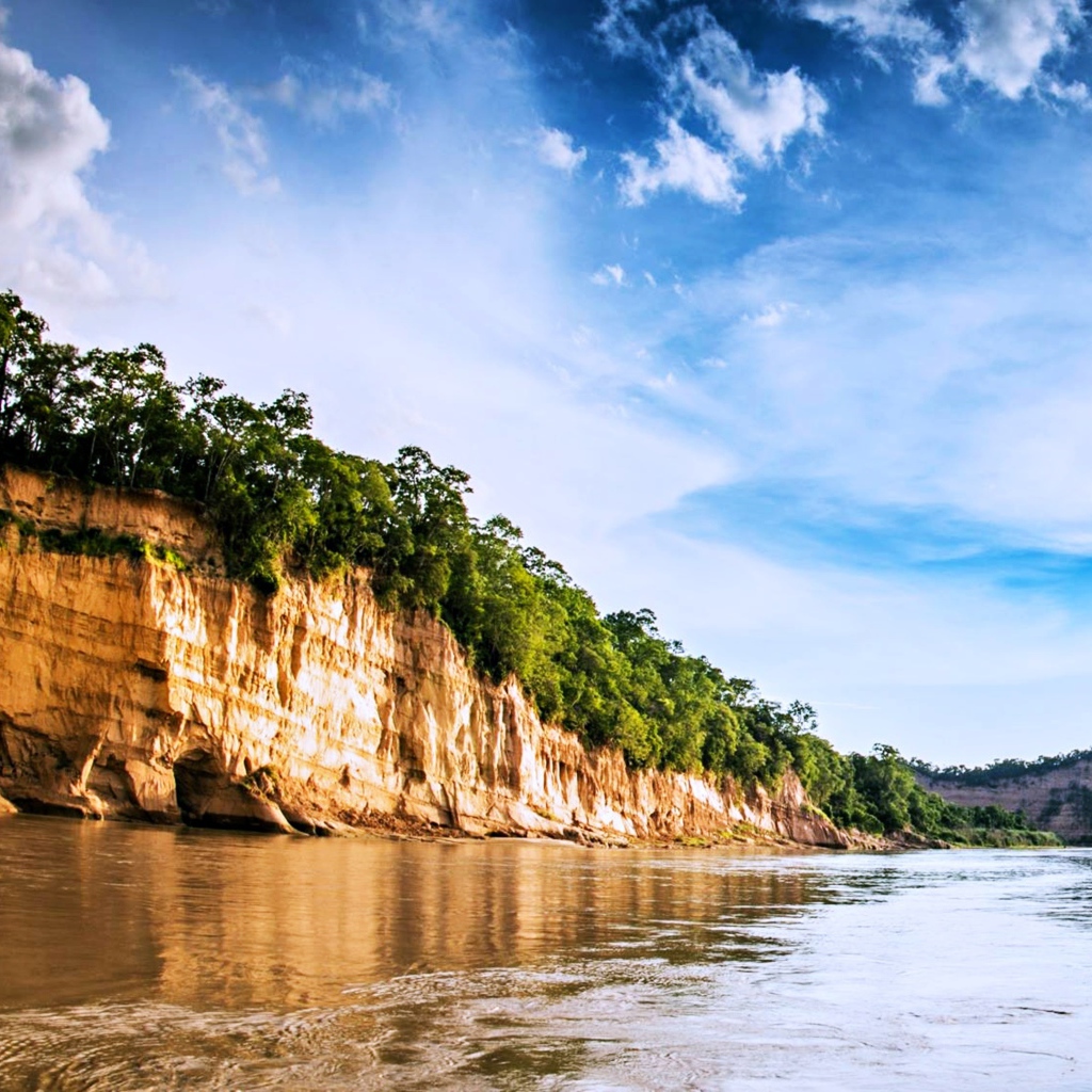 Скала на берегу реки под красивым небом