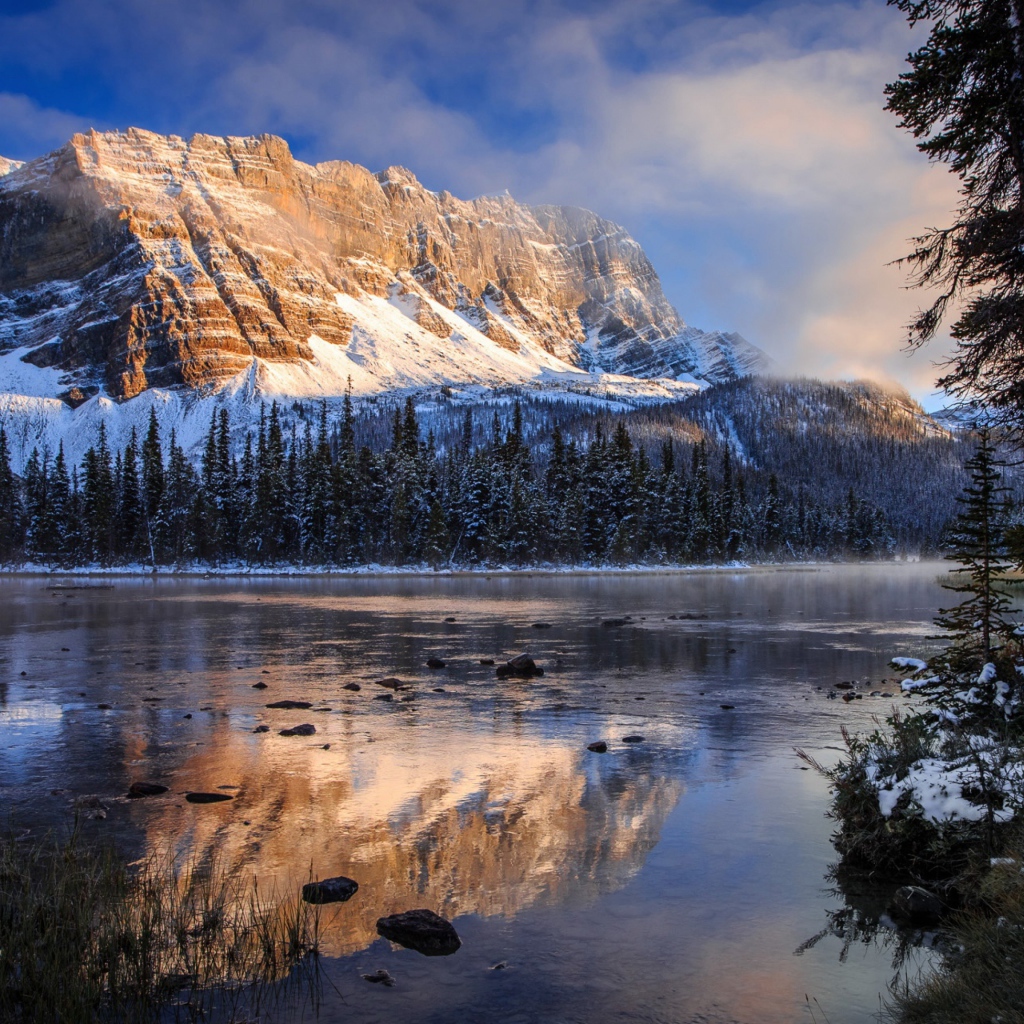 Покрытые снегом горы у заледеневшего озера