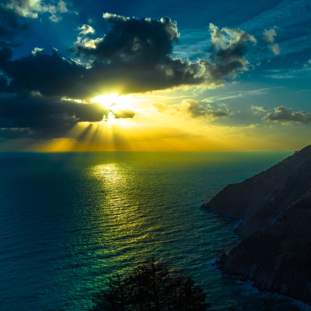 Лучи солнца пробиваются сквозь облака над океаном